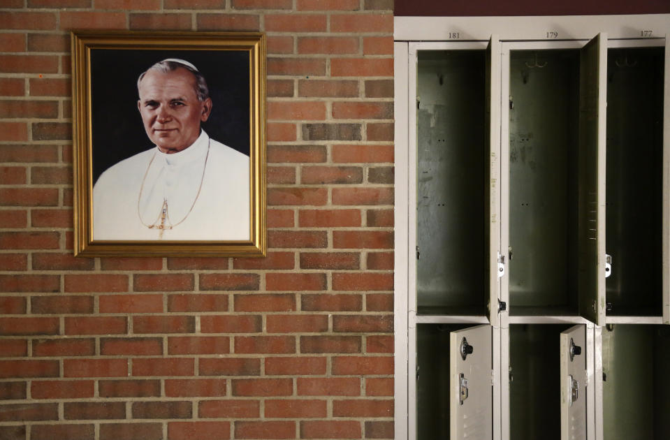 A portrait of St. John Paul II hangs beside a row of empty lockers in the main hallway of Quigley Catholic High School in Baden, Pa., Monday, June 8, 2020. (AP Photo/Jessie Wardarski)