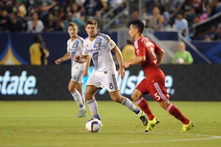 September 27, 2015; Carson, CA, USA; Los Angeles Galaxy midfielder Steven Gerrard (8) defends against FC Dallas midfielder Ezequiel Cirigliano (5) during the second half at StubHub Center. Gary A. Vasquez-USA TODAY Sports