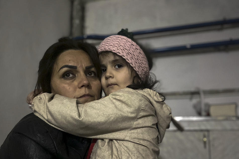 A girl embraces her relative sitting in a shelter during shelling in Stepanakert, Nagorno-Karabakh. Azerbaijan on Tuesday, Sept. 19, 2023, declared that it started what it called an "anti-terrorist operation" targeting Armenian military positions in the Nagorno-Karabakh region and officials in that region said there was heavy artillery firing around its capital. (AP Photo/Siranush Sargsyan)