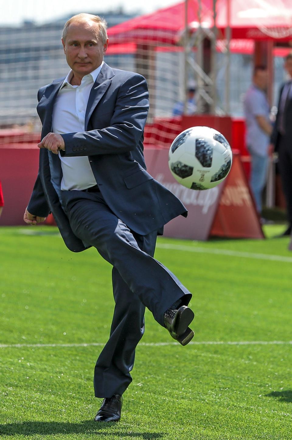 Vladimir Putin kicks a soccer ball.