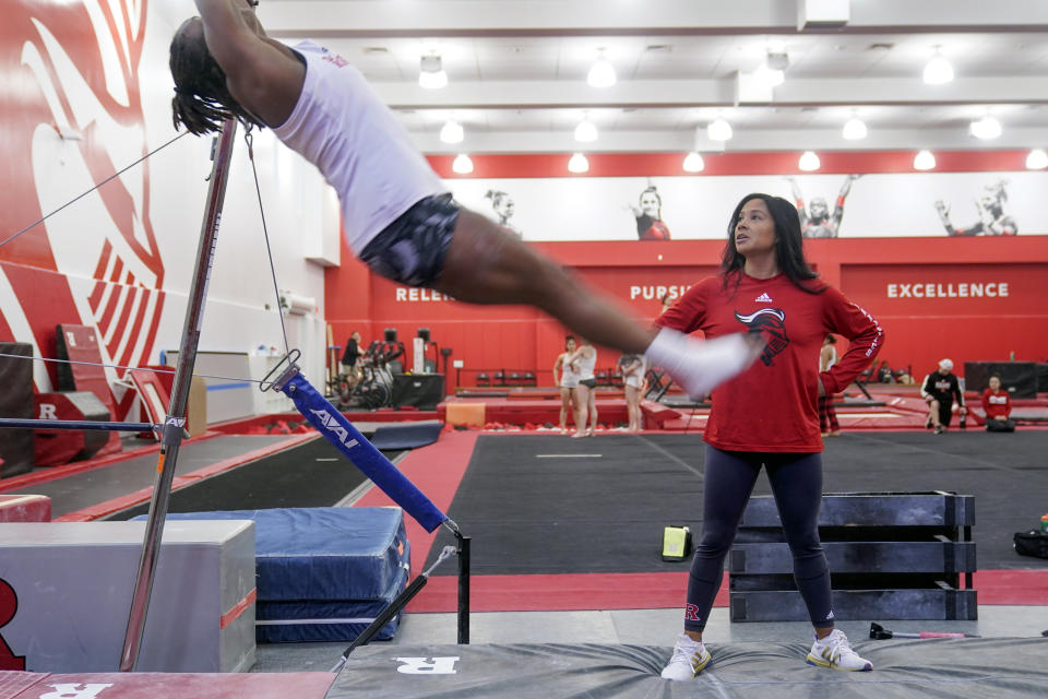 Rutgers women’s gymnastics coach Umme Salim-Beasley watches as student athletes practice at Rutgers in Piscataway, N.J., Thursday, March 2, 2023. The Supreme Court's decision to overturn Roe v. Wade has added another complicated layer for college coaches to navigate. When the daughters of Salim-Beasley were making their list of potential college destinations, they crossed off states where abortions were sharply restricted. (AP Photo/Seth Wenig)