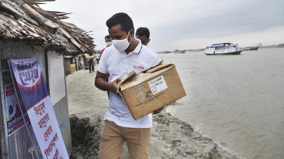 In this photo provided by Bidyanondo Foundation, a health worker arrives in a village with supplies at Banishanta near Mongla seaport in southwestern region of Bangladesh, on Sept. 1, 2020. A Bangladeshi charity has set up a floating hospital turning a small tourist boat into a healthcare facility to provide services to thousands of people affected by this year's devastating floods that marooned millions. (Bidyanondo Foundation via AP)