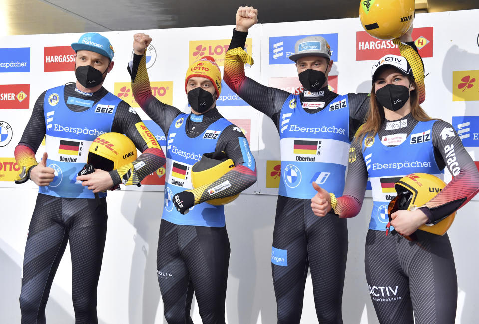 Toni Eggert, Sascha Benecken, Johannes Ludwig and Julia Taubitz from Germany, from left, are happy about the victory in the team relay competition at the Luge World Cup in Oberhof, Germany, Sunday, Jan. 16, 2022. (Martin Schutt/dpa via AP)