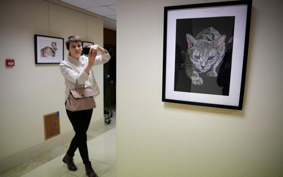 A journalist films with her smartphone during an opening of exhibition of artworks by Viktor Bout - Alexander Zemlianichenko