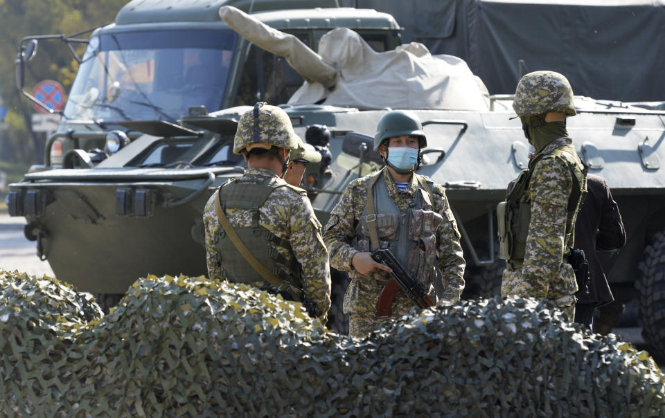 Kyrgyz army soldiers guard at a checkpoint on city street in Bishkek, Kyrgyzstan, Monday, Oct. 12, 2020. Kyrgyzstan's president on Monday ordered a new, week-long state of emergency in the country's capital after parliament failed to consider and approve his previous order within the legally required three days. (AP Photo/Vladimir Voronin)