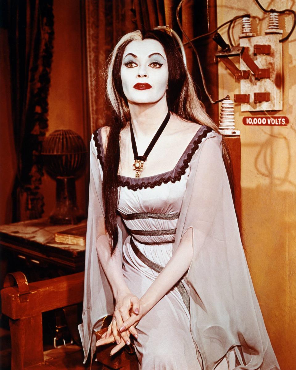 Lily Munster was the matriarch of TV's fictional Munster family. To get the look made famous by Yvonne De Carlo, you'll need a long pale pink or white dress, preferably with flowy sleeves, and a bold, gothic-inspired pendant necklace. For Munster's hair, get yourself a long black wig with white streaks or, if your hair is already long and dark, get some <a href="https://www.partycity.com/white-hair-spray-182046.html" target="_blank" rel="noopener noreferrer">white hair spray</a> and add them yourself. Add a rope or ribbon belt and bold red lip, and you're set.<strong>&nbsp;</strong>