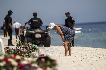 A tourist reads messages left at a makeshift memorial at the beach near the Imperial Marhaba resort, which was attacked by a gunman in Sousse, Tunisia, June 29, 2015. REUTERS/Zohra Bensemra
