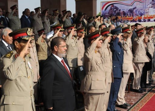 Picture made available by the Egyptian presidency on June 30, shows President Mohamed Morsi (2nd L) watching a parade next to military council chief, Field Marshal Hussein Tantawi (L) and other senior officers in Cairo. Morsi began his first full day in office on Sunday, but with his powers sharply circumscribed by the military that has ruled since Hosni Mubarak was ousted from power last year