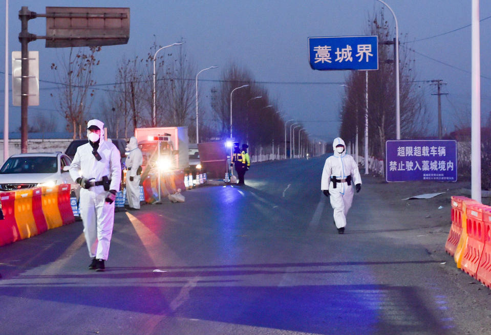 Image: Police officers and staff members inspect vehicles at a checkpoint on the borders of Gaocheng district on a provincial highway (China Daily / Reuters)