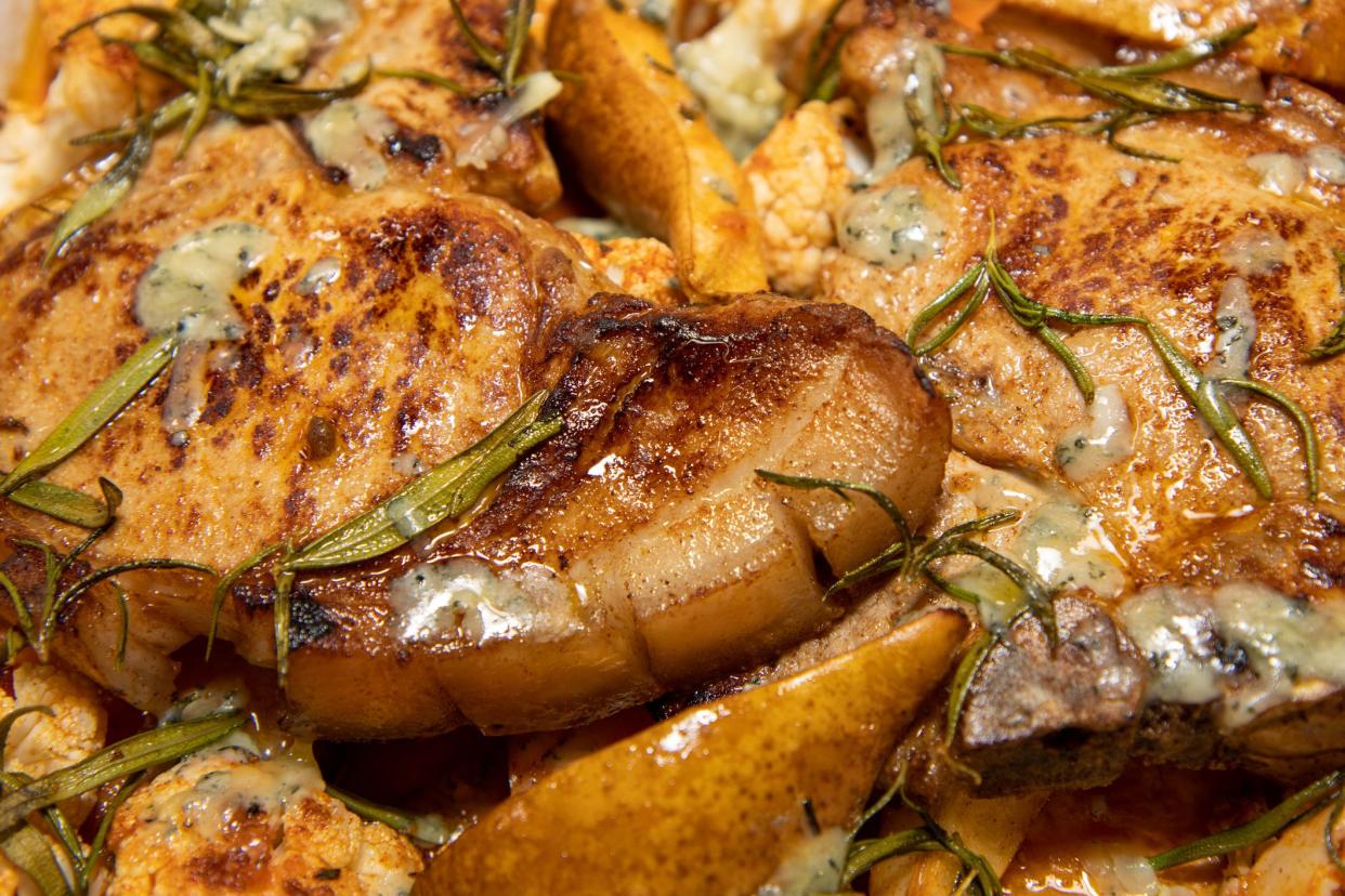 A delicious dish of Pork Pear sweet potato and stilton tray roast on a wooden kitchen work top