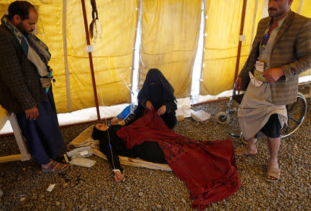A woman suffering from cholera lies on the ground in a tent as she waits for medical care at a cholera treatment center in Sanaa, Yemen March 10, 2019. Picture taken March 10, 2019. REUTERS/Khaled Abdullah