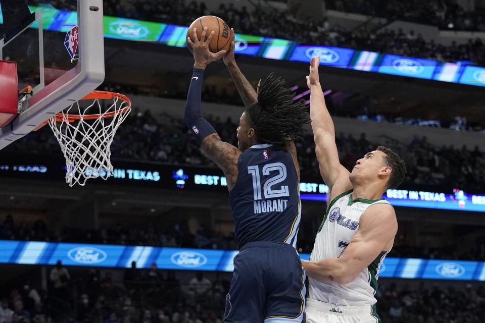 Memphis Grizzlies guard Ja Morant (12) goes up for a dunk after getting past Dallas Mavericks center Dwight Powell (7) in the first half of an NBA basketball game in Dallas, Sunday, Jan. 23, 2022. (AP Photo/Tony Gutierrez)
