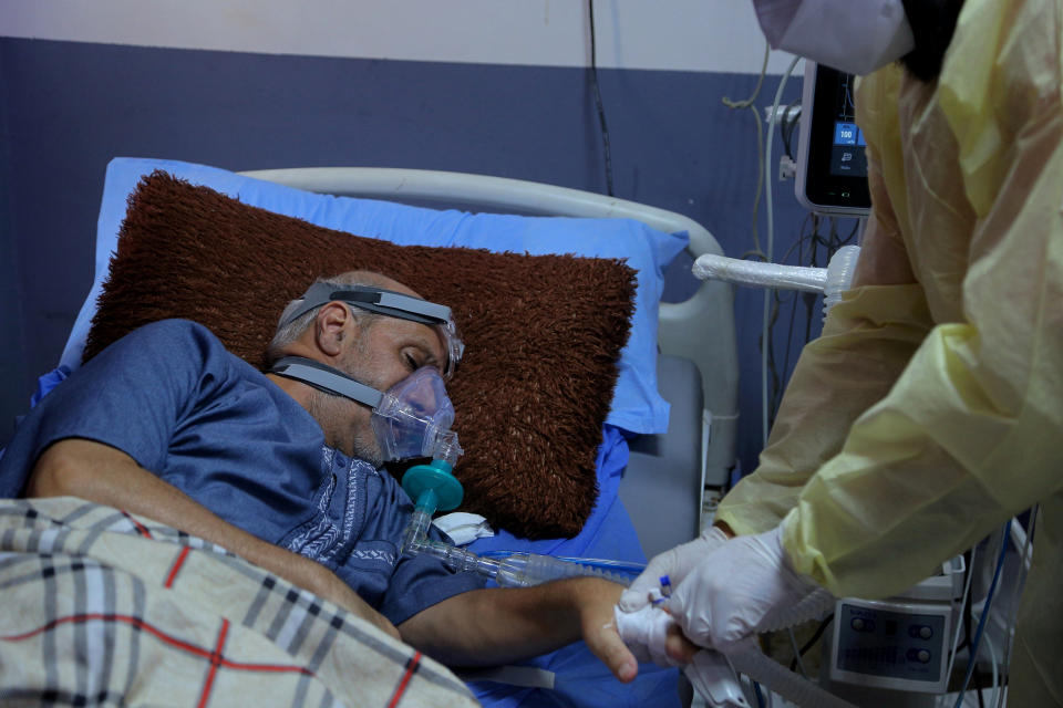 A coronavirus patient receives treatment at a hospital in Najaf, Iraq, Wednesday, July 14, 2021. Infections in Iraq have surged to record highs amid a third wave spurred by the more aggressive delta variant, and long-neglected hospitals suffering the effects of decades of war are overwhelmed with severely ill patients. (AP Photo/Anmar Khalil)