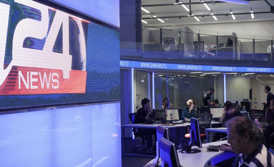 In this Sunday, July 28, 2013 photo, journalists work inside a studio of the new television channel I24news in Tel Aviv, Israel. The station's founders insist they are not an Israeli version of Al-Jazeera, the powerful broadcaster from the Gulf. They say they receive no government funding, hold no political affiliation and pledge to cover the news dispassionately and objectively. (AP Photo/Dan Balilty)