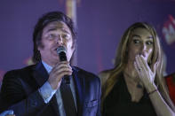 Presidential candidate of the Liberty Advances coalition Javier Milei speaks to supporters outside his campaign headquarters after winning the runoff election in Buenos Aires, Argentina, Sunday, Nov. 19, 2023. At right his girlfriend Fatima Florez. (AP Photo/Rodrigo Abd)