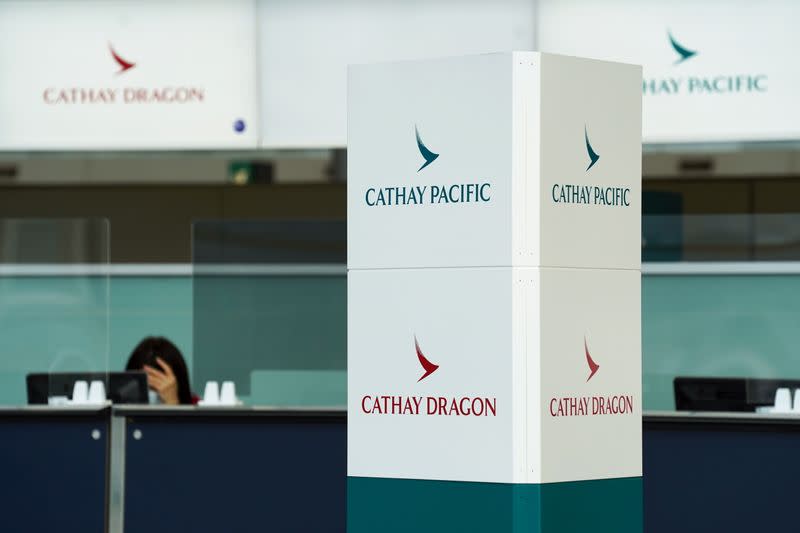 Cathay Pacific and Cathay Dragon logos are seen near a counter at Hong Kong International Airport