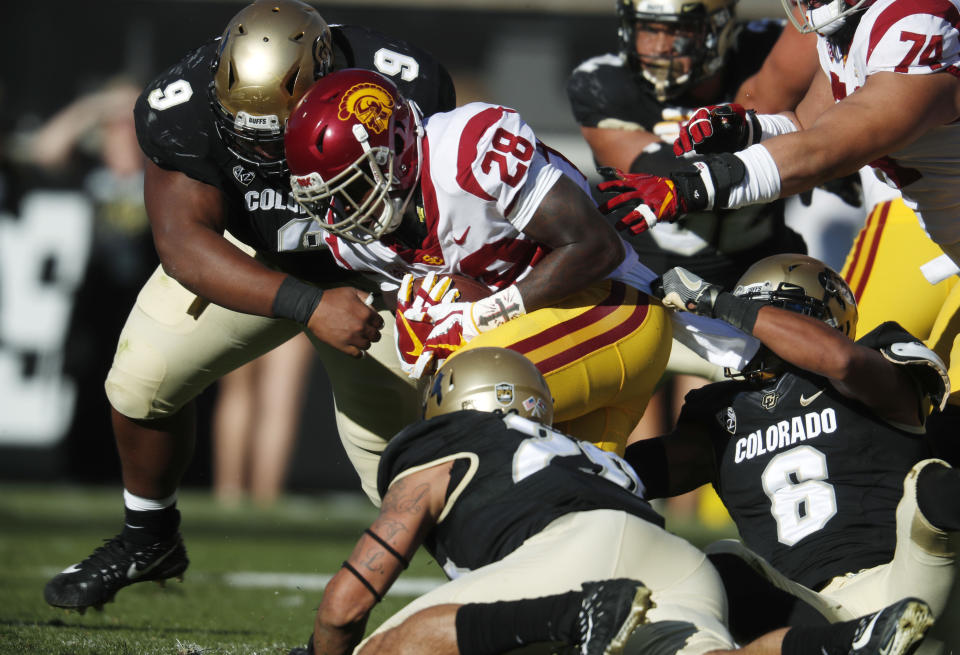 USC running back Aca’Cedric Ware, center, is tackled after a short gain by, from left, Colorado nose tackle Javier Edwards, linebacker Drew Lewis and defensive back Evan Worthington in the first half of an NCAA college football game Saturday, Nov. 11, 2017, in Boulder, Colo. (AP Photo/David Zalubowski)