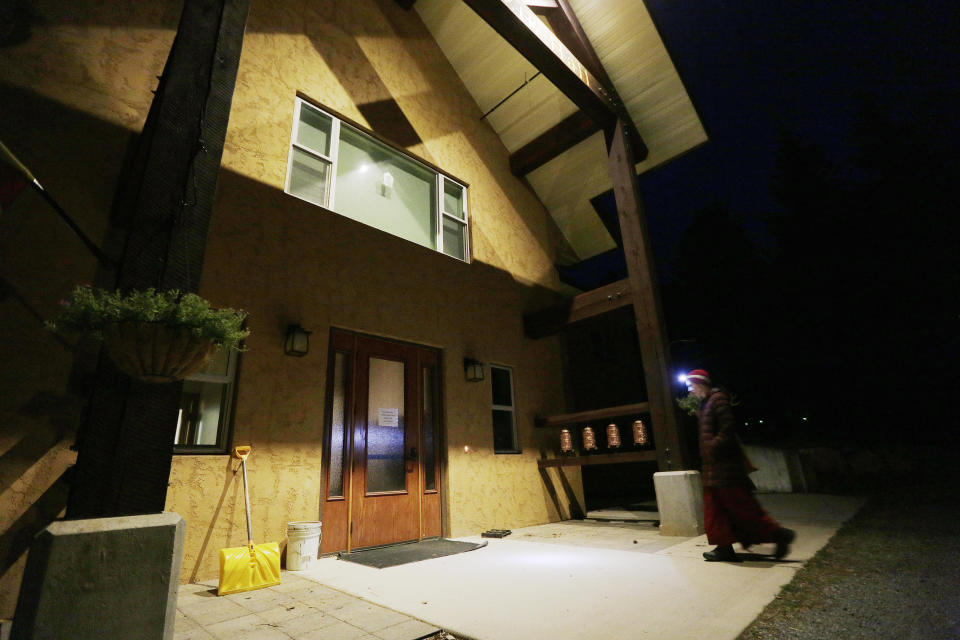 Thubten Rinchen, a fully ordained Buddhist nun, walks into Chenrezig Hall in the morning, at Sravasti Abbey, Thursday, Nov. 18, 2021, in Newport, Wash. (AP Photo/Young Kwak)