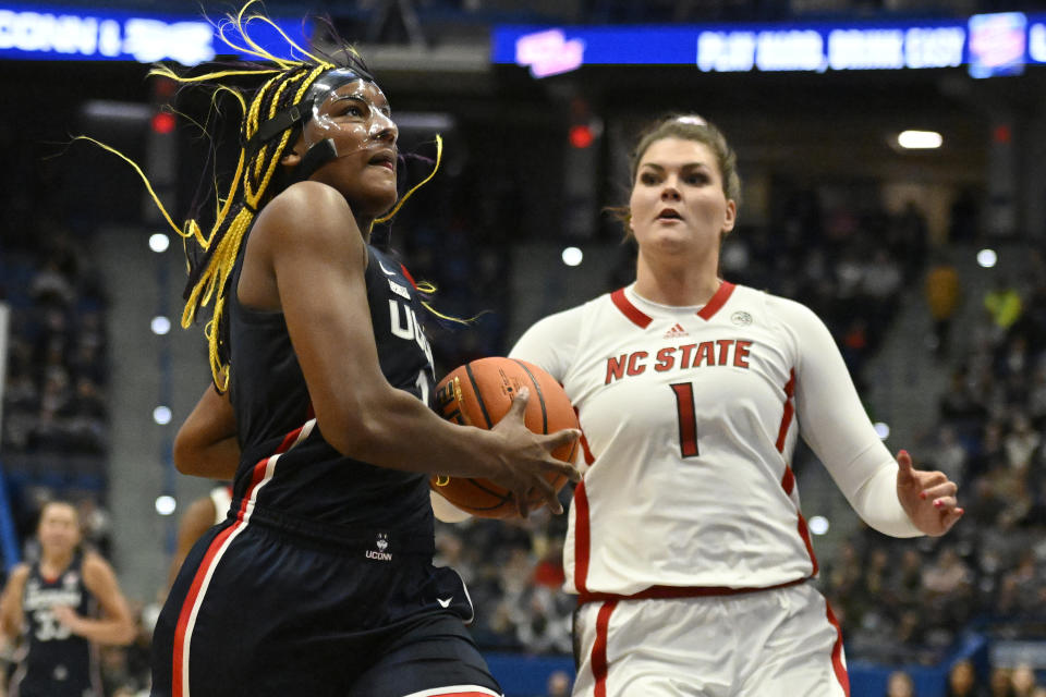 Connecticut's Aaliyah Edwards drives to the basket as NC State's River Baldwin (1) defends during the first half of an NCAA college basketball game, Sunday, Nov. 20, 2022, in Hartford, Conn. (AP Photo/Jessica Hill)