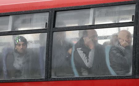 Passengers sit on a coach after they arrived with "Spirit of Piraeus" cargo container ship in Bari harbour, after the car ferry Norman Atlantic caught fire in waters off Greece December 29, 2014. REUTERS/Yara Nardi