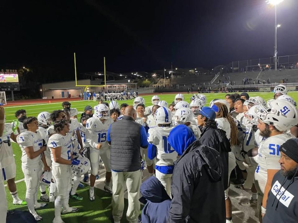 Capital Christian coach Saul Patu talks to his players after beating Wood in the playoffs on Nov. 4, 2022.