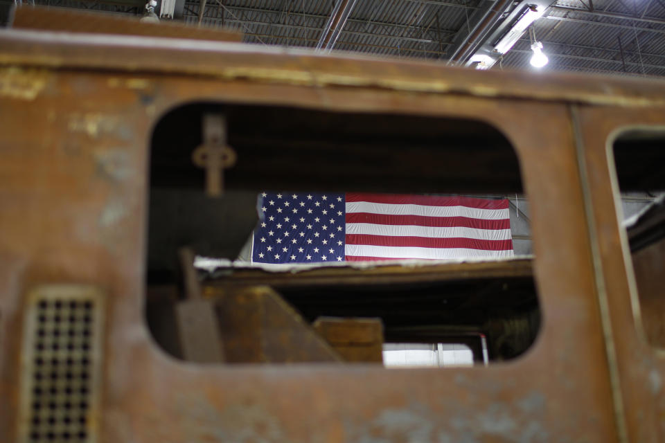 An American flag is visible through the rusted window of a destroyed Fire Engine inside Hangar 17 at New York's John F. Kennedy International Airport June 16, 2011. A program operated by the Port Authority of New York and New Jersey, The World Trade Center steel program, is selecting portions of the steel recovered from the Center and donating it to cities, towns, firehouses and museums around the U.S. and the world who request it for use in 911 memorial sites in time for the 10 year anniversary of the 2001 attacks. Picture taken June 16, 2011. (REUTERS/Mike Segar)
