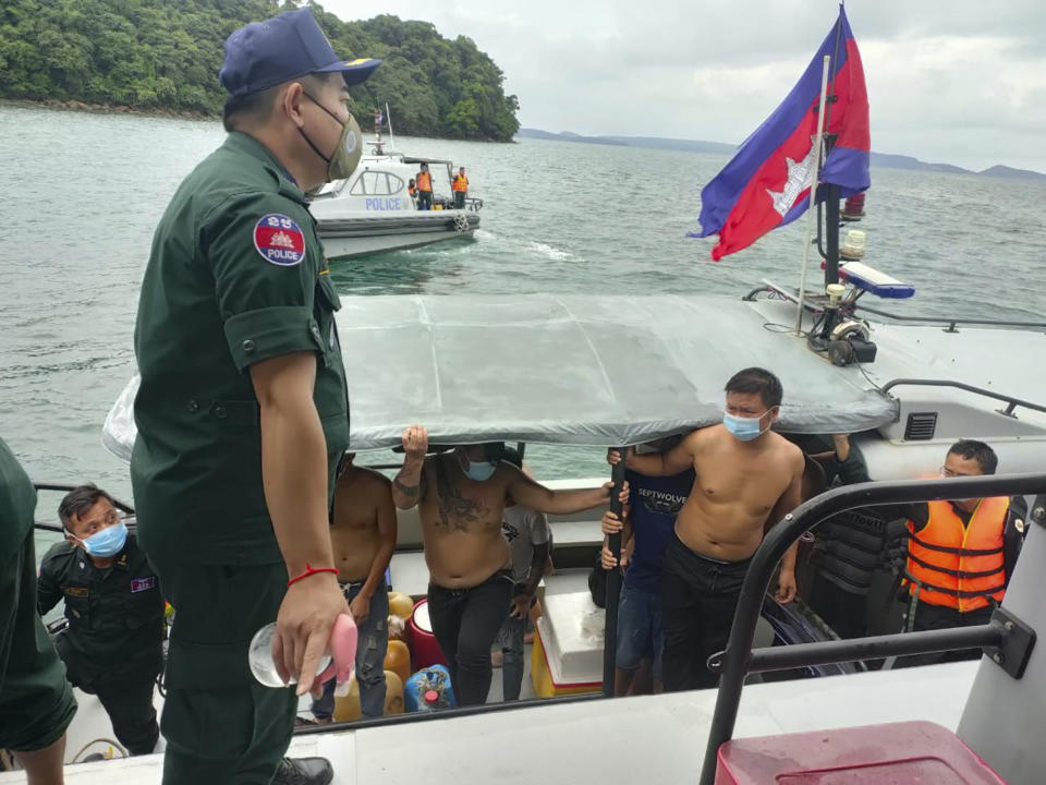 In this photo provided by the Sihanoukville Province Authority Police, Chinese nationals get off from a speedboat after being rescued from a ship sinking, at an island in Preah Sihanouk Province, southwestern Cambodia on Thursday, Sept. 22, 2022. Cambodian authorities were searching Friday, Sept. 23, for more than 20 people in the Gulf of Thailand after their boat sank near Cambodia's Koh Tang island, authorities said. (Preah Sihanouk province Authority Police via AP)