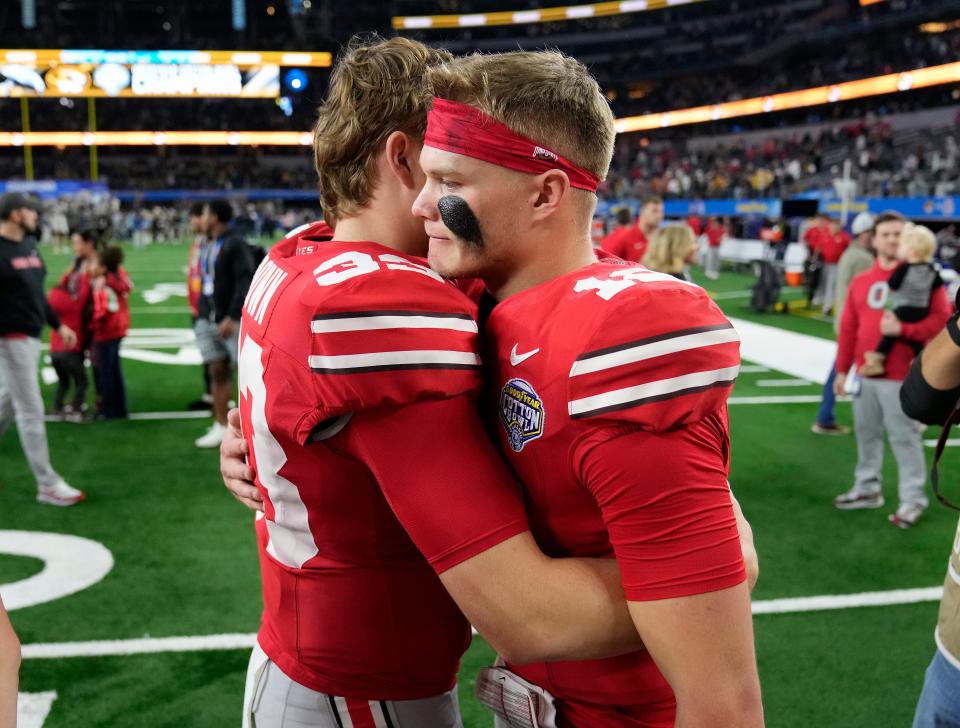 Dec 29, 2023; Arlington, Texas, USA; Ohio State Buckeyes quarterback Devin Brown (33) hugs Ohio State Buckeyes quarterback Lincoln Kienholz (12) after losing 14-3 to Missouri Tigers in the Goodyear Cotton Bowl Classic at AT&T Stadium.