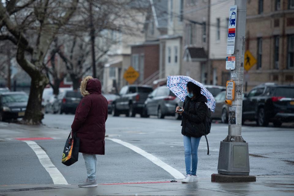 Commuters wait for an NJ Transit Bus on the corner of J.F. Kennedy Blvd and McAdoo Ave in Jersey City, N.J. on Wednesday April 6, 2022. 