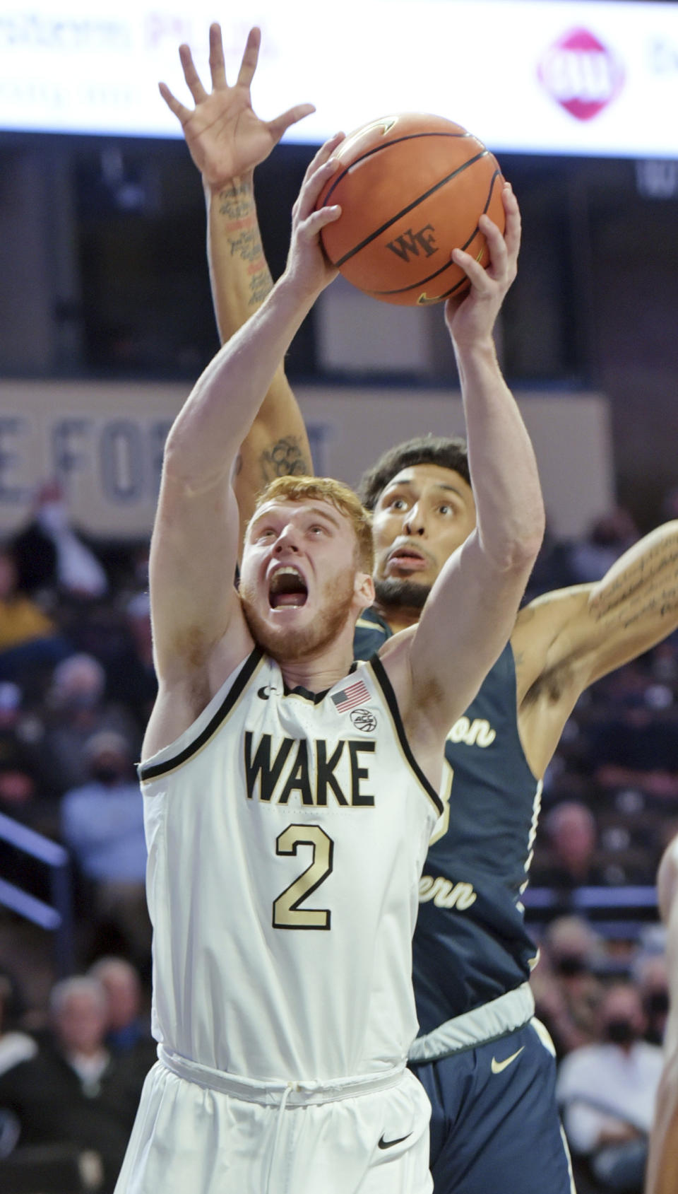 Wake Forest's Cameron Hildreth gets past Charleston Southern's Sean Price for a basket during the first half of an NCAA college basketball game Wednesday, Nov. 17, 2021, in Winston-Salem, N.C. (Walt Unks/The Winston-Salem Journal via AP)