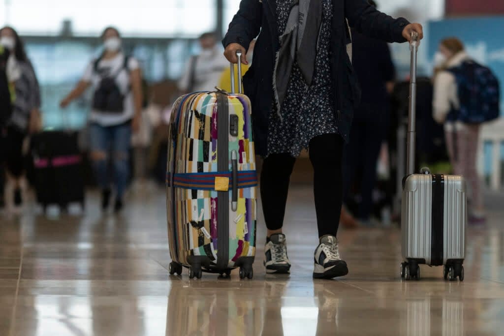 Passengers carry suitcases at Berlin Brandenburg Airport (BER) on July 1, 2021, in Schoenefeld, Germany. (Photo by Maja Hitij/Getty Images)