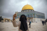 A Muslim woman takes a photo next to the Dome of the Rock Mosque in the Al Aqsa Mosque compound in Jerusalem's old city, Friday, Nov. 6, 2020. The Palestinian leadership has condemned the United Arab Emirates' decision to forge ties with Israel as a "betrayal," but it could lead to a tourism bonanza for Palestinians in east Jerusalem as Israel courts wealthy Gulf travelers. (AP Photo/Mahmoud Illean)