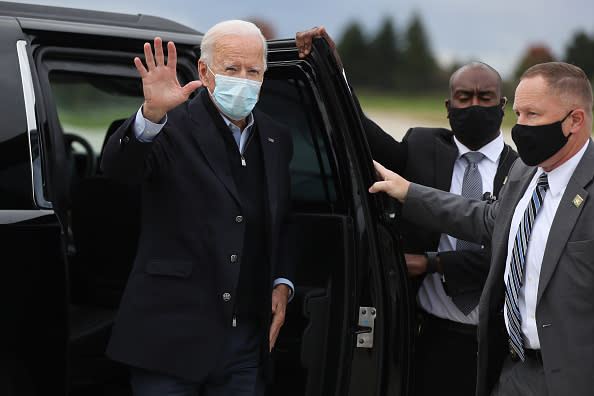 Wearing a mask to reduce the risk posed by the coronavirus, Democratic presidential nominee Joe Biden waves while preparing to board his plane at Gerald Ford Airport after campaigning in Grand Rapids, Michigan. 