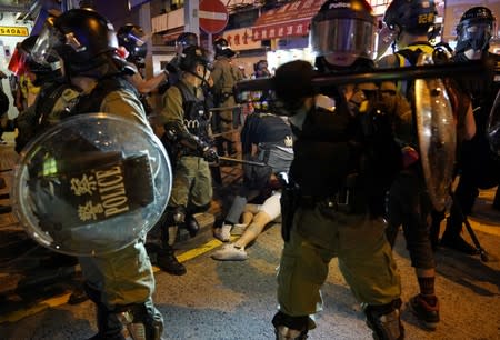 Police officers detain an anti-government protester during a rally outside Mong Kok Police Station, in Hong Kong