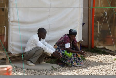 Congolese farmer Marcela Kaswera, 45, and her husband wait outside the Biosecure Emergency Care Unit at the ALIMA Ebola treatment centre in Beni