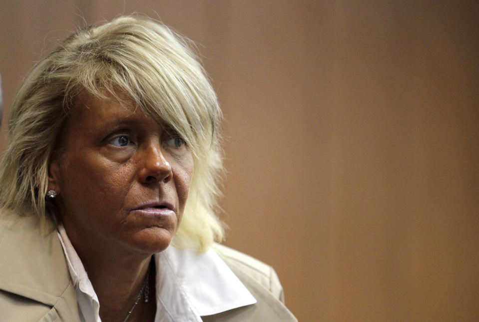 FILE - In this May 2, 2012 file photo, Patricia Krentcil, 44, waits to be arraigned at the Essex County Superior Court in Newark, N.J., where she appeared on charges of endangering her 5-year-old child by taking her into a tanning salon. Connecticut novelty company HeroBuilders is selling a "tanorexic" action figure based on Krentcil. (AP Photo/Julio Cortez, File)
