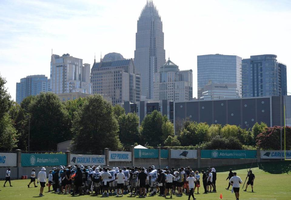 The Charlotte skyline rises in the background as the Carolina Panthers practice during training camp on Tuesday, August 18, 2020.