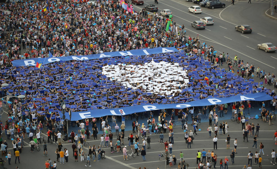 People form a heart shape during a pro-Europe event dubbed "All for Europe" outside the government headquarters in Bucharest, Romania, Sunday, May 19, 2019. Thousands gathered to express their support for Europe, calling for a high attendance at the upcoming European Parliament elections that will take place on May 26. (AP Photo/Vadim Ghirda)