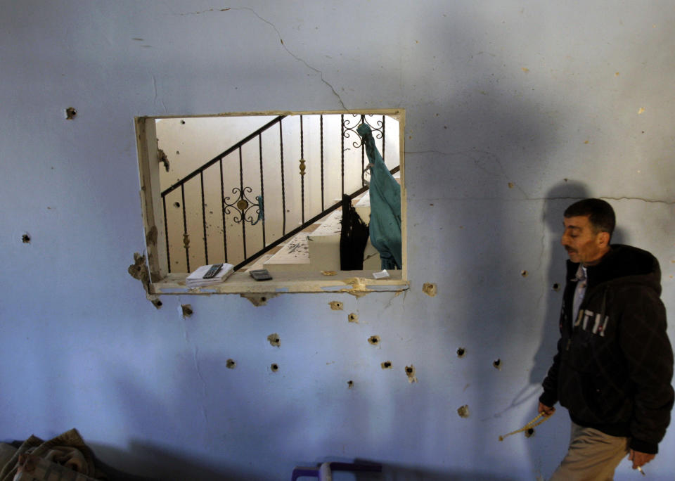 A Palestinians walks past bullet holes in the wall inside the home of Hamza Abu el-Heija, where he was killed by Israeli troops, in the West Bank refugee camp of Jenin, Saturday, March 22, 2014. Israeli troops killed at least four Palestinians in an early morning raid that was followed by a clash with angry protesters in a West Bank town on Saturday, the Israeli military and Palestinian security officials said, in the deadliest incident in months. The Israeli military said the raid aimed to arrest Hamza Abu el-Heija, a 22-year-old Hamas operative wanted for involvement in shooting and bombing attacks against Israelis. (AP Photo/Mohammed Ballas)