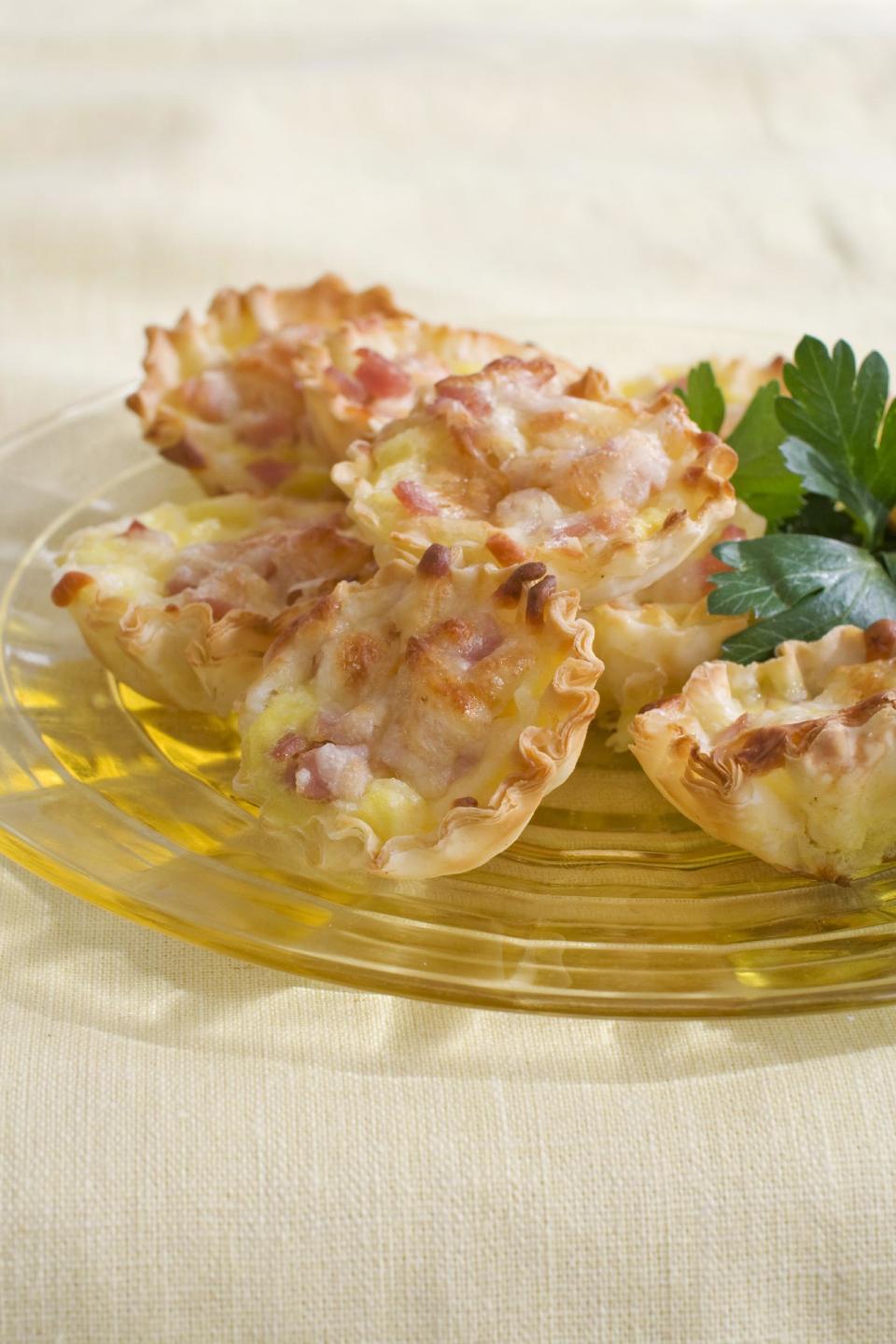 In this image taken on March 4, 2013, mini cheese quiches are shown served on a plate in Concord, N.H. (AP Photo/Matthew Mead)