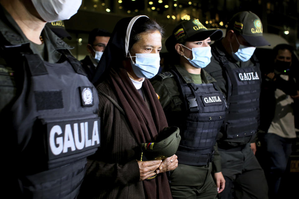 FILE — Colombian nun Gloria Cecilia Narvaez, second from left, is escorted by police after her arrival at El Dorado airport in Bogota, Colombia, in this Tuesday, Nov. 16, 2021 file photo, after she was released on Oct. 10 by her kidnappers. Pope Francis authorized spending up to 1 million euro to free Narvaez who was held captive by al-Qaida-linked militants in Mali, Cardinal Angelo Becciu testified at the Vatican's big financial fraud trial Thursday, May 5, 2022, revealing previously top secret negotiations that Francis authorized to hire a British security and intelligence firm to find the nun and pay for her liberation. (AP Photo/Leonardo Muñoz)