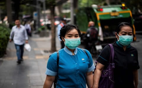 Respiratory face masks are a common sight in Thailand's capital - Credit: Getty