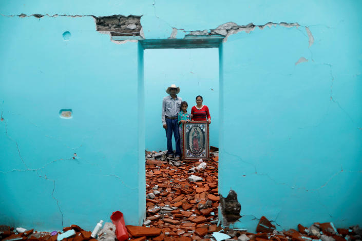 <p>Luis Medina, 36, a farm worker, Maria Teresa Espinoza, 35, housewife, and Maria de Jesus Medina, 9, pose for a portrait inside their house which was badly damaged after an earthquake in San Jose Platanar, at the epicentre zone, Mexico, September 28, 2017. They were able to rescue some furniture and are waiting for their home to be demolished. They are living in their backyard and hope for it to be rebuilt. “The most valuable thing that I recovered was the picture of the Virgin,” Espinoza said. (Photo: Edgard Garrido/Reuters) </p>