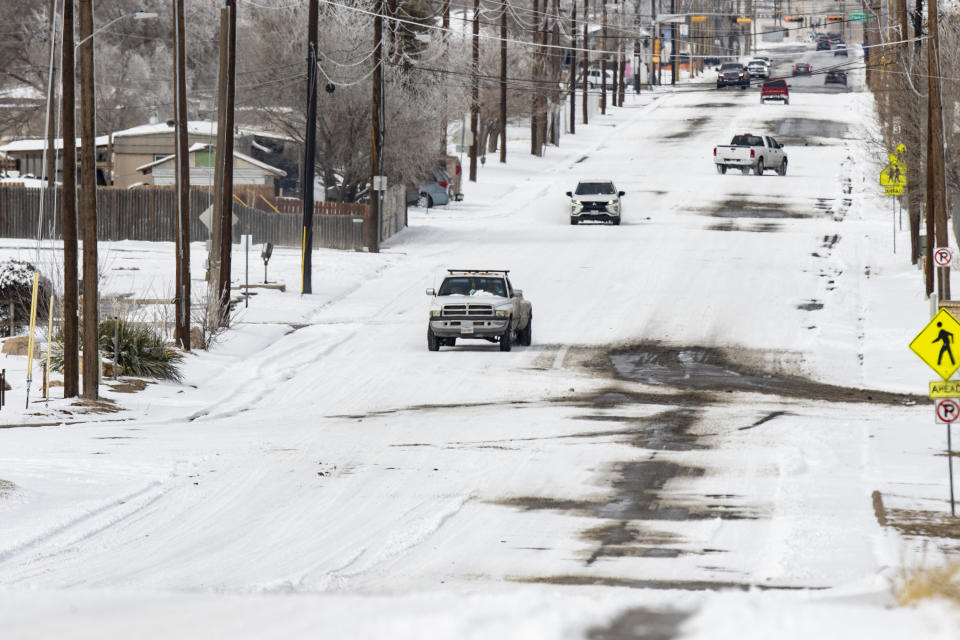 Ice and snow blanket parts of a Grandview Avenue and Charles Walker Road, Monday, Feb. 15, 2021 in Odessa, Texas. A sprawling blast of winter weather across the U.S. plunged Texas into an unusually snowy emergency Monday that knocked out power for more than 2 million people, shut down grocery stores and air travel and closed schools ahead of frigid days still to come. (Jacob Ford/Odessa American via AP)