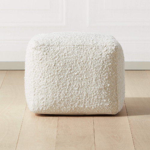 CB2 boucle ivory ottoman against white background