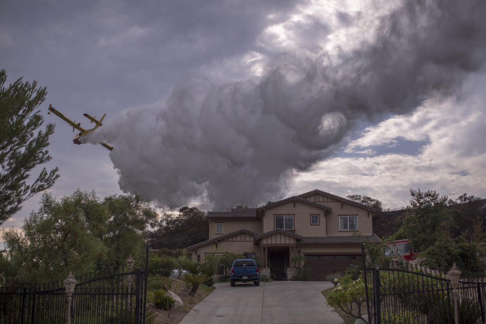 <p>A Super Scooper CL-415 firefighting aircraft from Canada makes a drop to protect a house during the La Tuna Fire on Sept. 3, 2017 near Burbank, Calif. (Photo: David McNew/Getty Images) </p>