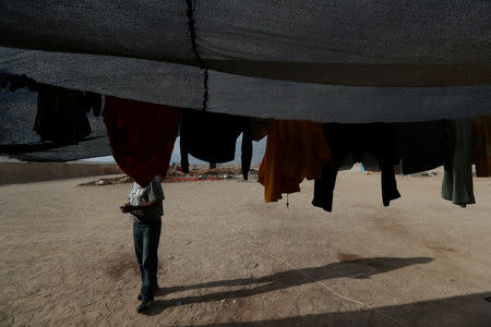 Undocumented Bolivian migrant known as Elvis, 40, uses a mobile phone after work, at the Chilean and Peruvian border near Arica, Chile, November 17, 2018. REUTERS/Ivan Alvarado