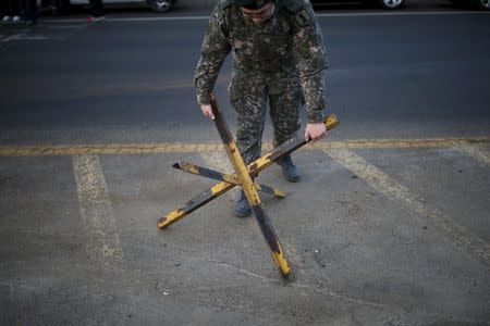 A South Korean soldier sets up a barricade at a checkpoint on the Grand Unification Bridge which leads to the inter-Korean Kaesong Industrial Complex in North Korea, just south of the demilitarized zone separating the two Koreas, in Paju, South Korea, February 11, 2016. REUTERS/Kim Hong-Ji