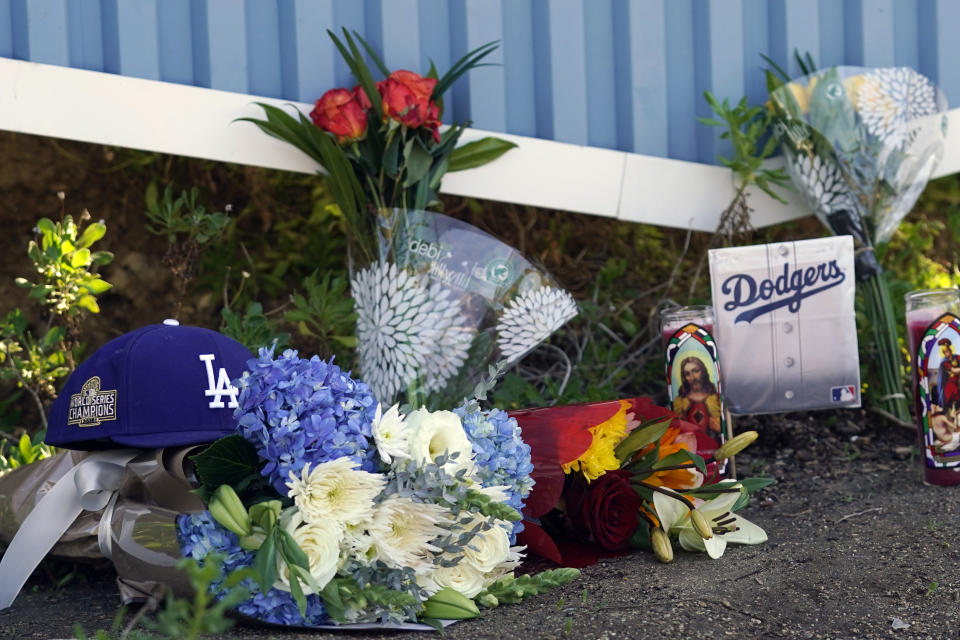 Memorabilia, flowers and candles are placed outside of Dodger Stadium Friday, Jan. 8, 2021, in Los Angeles. Tommy Lasorda, the fiery Hall of Fame manager who guided the Los Angeles Dodgers to two World Series titles and later became an ambassador for the sport he loved during his 71 years with the franchise, has died. He was 93. (AP Photo/Marcio Jose Sanchez)