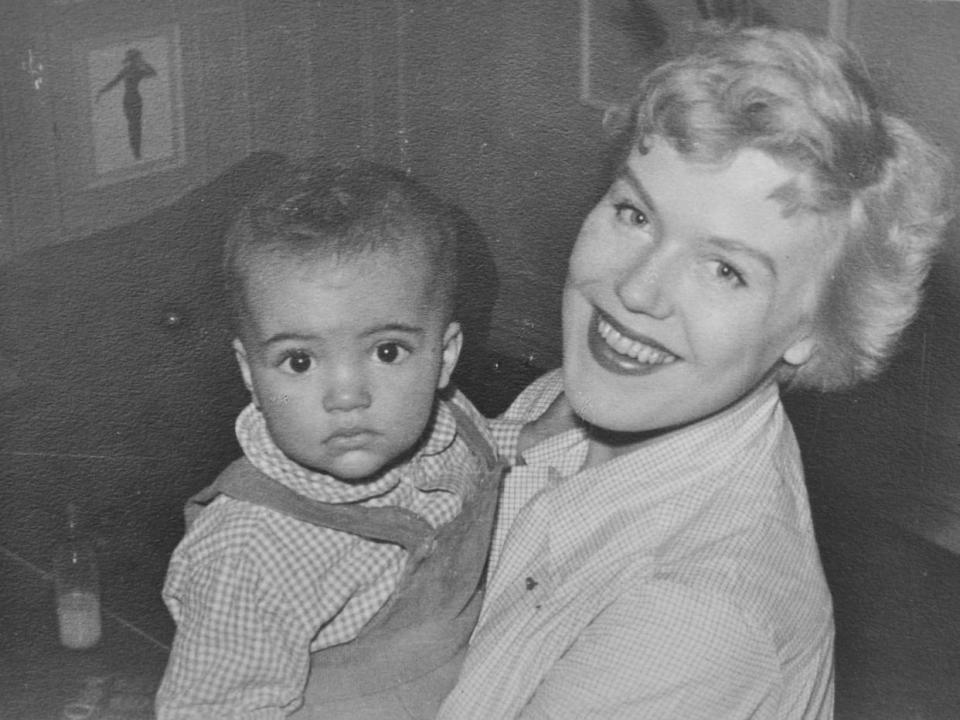 A black and white photograph of Christine Jacobsen being held by her mother when she was and infant.